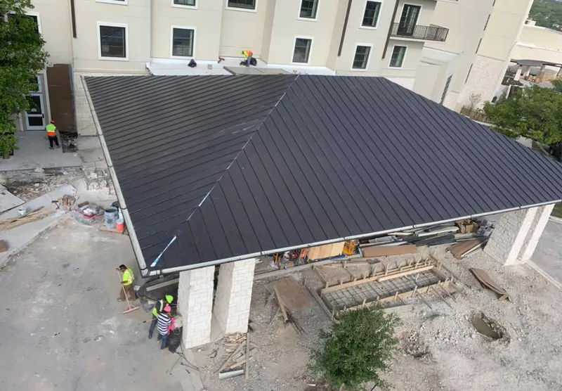 Metal roofing installation team working on a commercial building in Mack